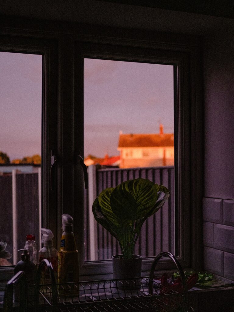 Casement windows above a kitchen sink overlooking a neighborhood at sunset - St. Louis casement window installers - Kirkwood Home Gallery