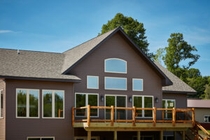 the back of a home with white sliding patio doors leading to a deck - Kirkwood Home Gallery